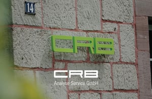Зелений напис CRB на фасаді CRB в Хардегсені, логотип видно на передньому плані