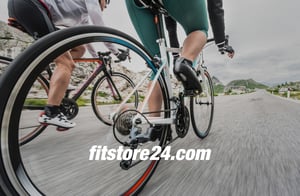 Чоловік на гоночному велосипеді з логотипом Fitstore24 на передньому плані.
