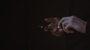 Хтось тримає в руці смартфон і дивиться на екран