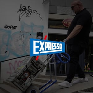 Mann mit beladener Sackkarre im Treppenhaus, im Vordergrund ist das EXPRESSO-Logo zu sehen.